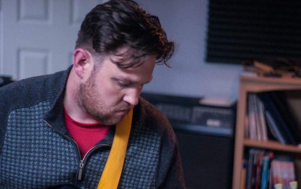 miles head playing guitar looking down