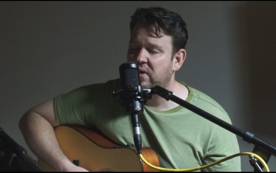 miles playing acoustic guitar and singing