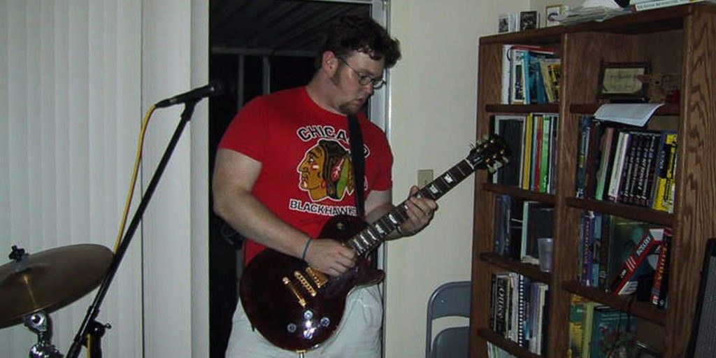 man playing electric guitar in residence